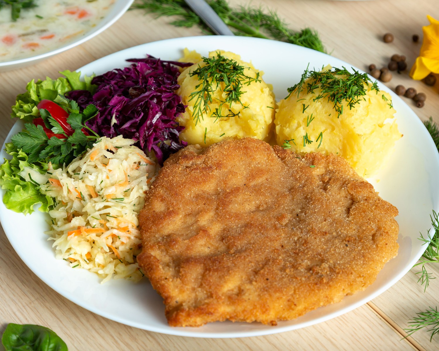 Breaded pork cutlet with mashed potatoes and salads